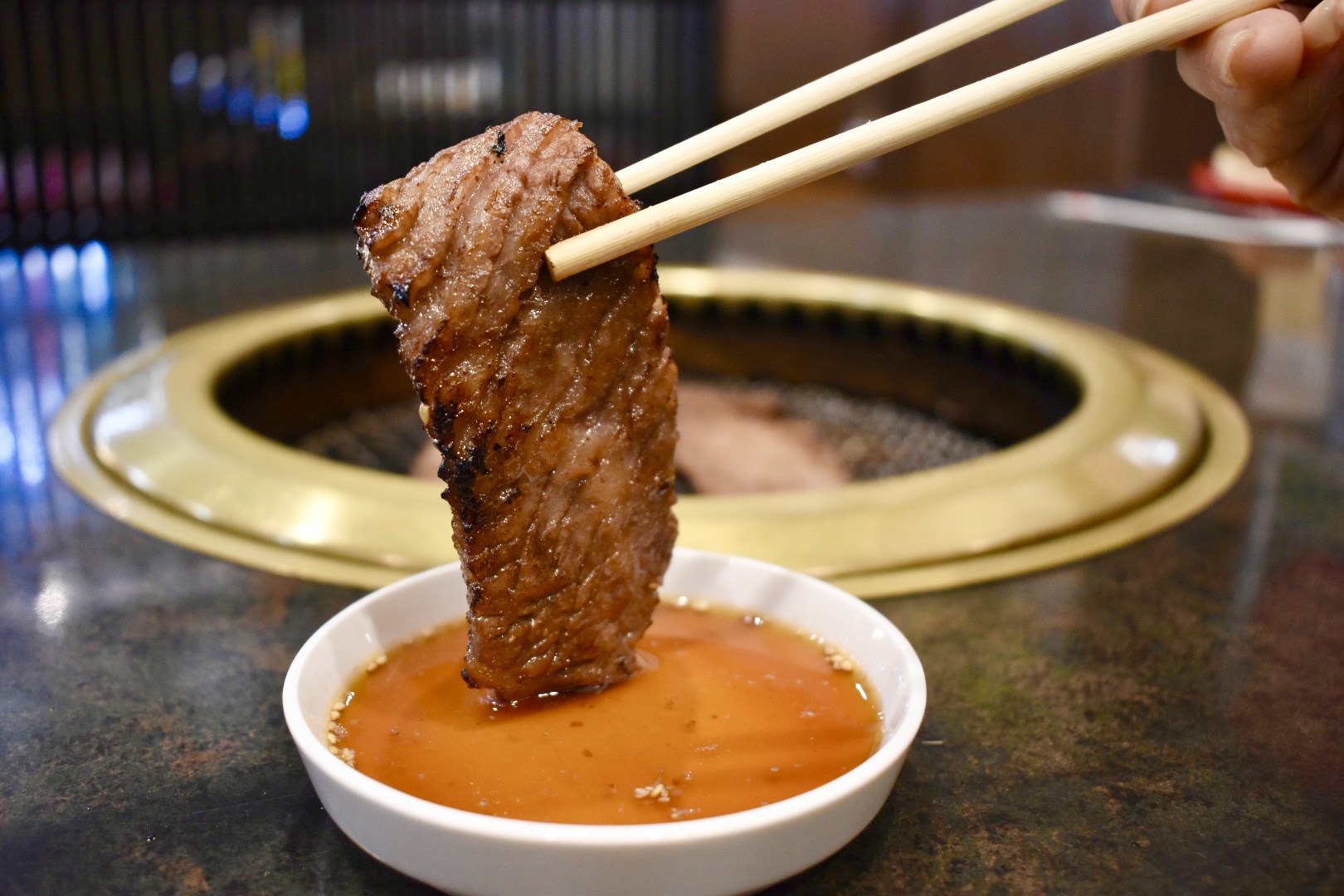 焼肉をタレにつけている様子